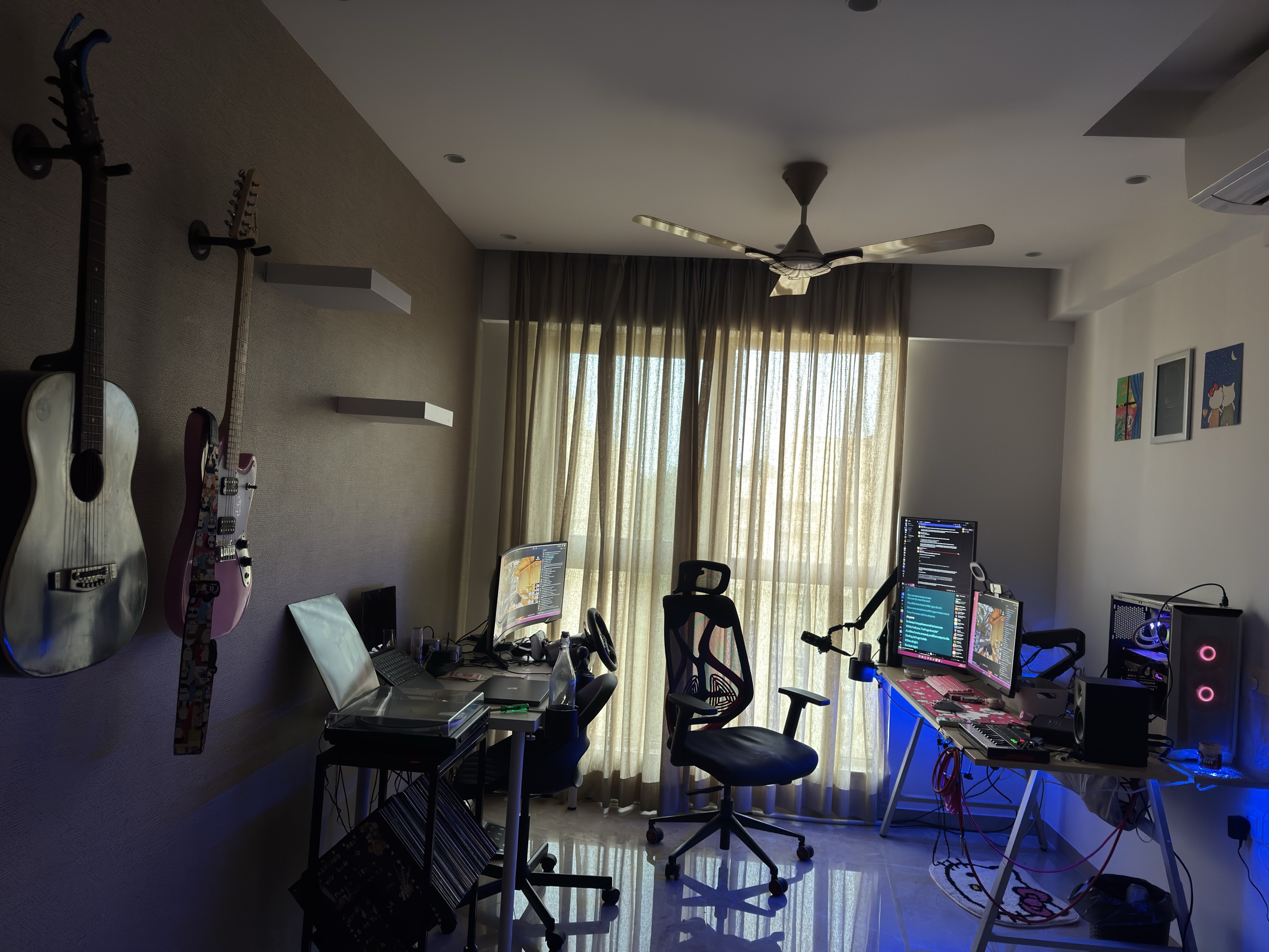 My home setup with guitars, a turntable and vinyl records, and a dual-desk computer workspace.